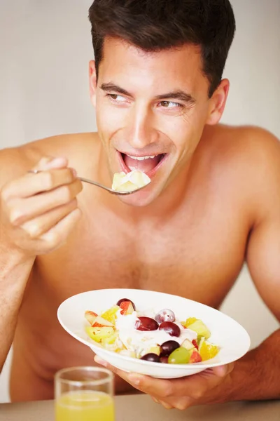 Создание идеального тела с здоровым завтраком. Обрезанный кадр мускулистого человека, завтракающего. — стоковое фото