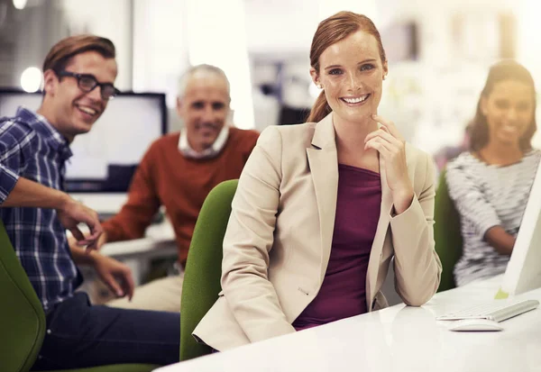 Ze zijn capabel en succesvol. Portret van een jonge kantoormedewerker met collega 's op de achtergrond. — Stockfoto