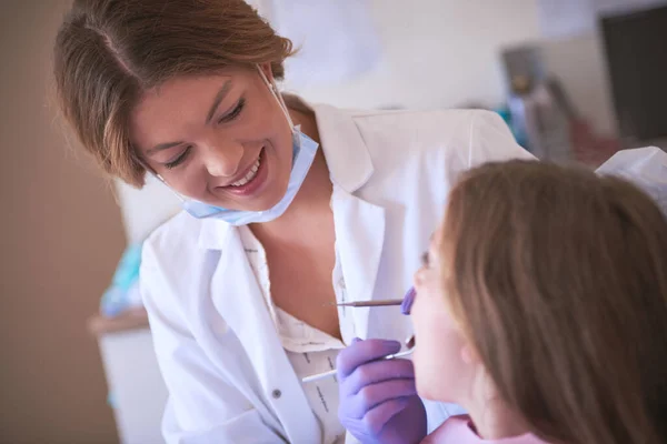 Ha una grande esperienza in odontoiatria pediatrica. Colpo ritagliato di un dentista che esamina i denti di una bambina. — Foto Stock