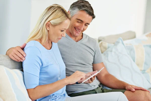 This home is connected. Shot of a mature couple sitting at home using a digital tablet. — Stock Photo, Image
