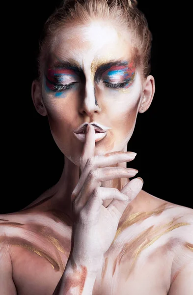Verloren in einem farbenfrohen Traum. Studioaufnahme einer jungen Frau, die mit Farbe im Gesicht posiert, isoliert auf schwarz. — Stockfoto
