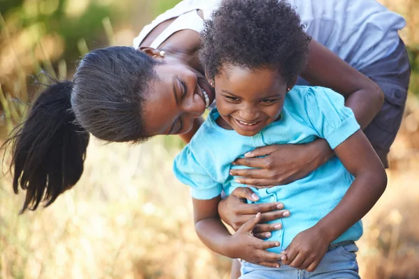 Te tengo a ti. Una joven madre africana feliz pasando tiempo con su hija mientras está al aire libre en la naturaleza. —  Fotos de Stock