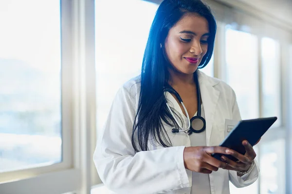 Sto accedendo a tutti i registri dei suoi pazienti su un unico dispositivo. Foto di una dottoressa che usa una tavoletta digitale in un ospedale. — Foto Stock