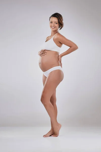 O momento mais bonito da sua vida. Retrato de estúdio de uma bela jovem grávida posando contra um fundo cinza. — Fotografia de Stock