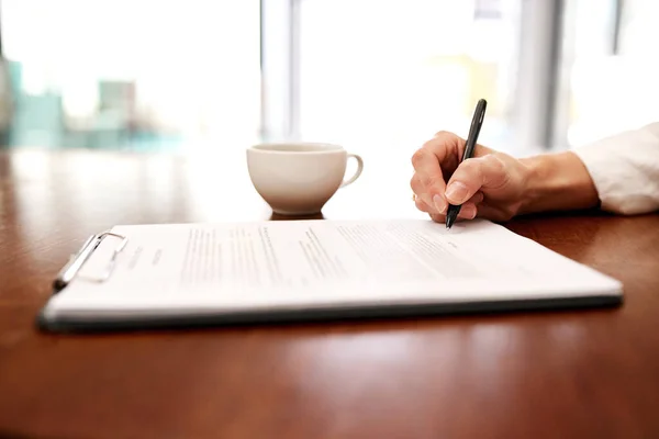 Poner bolígrafo sobre papel en una nueva propuesta. Primer plano de una irreconocible mujer de negocios llenando papeleo en una oficina. —  Fotos de Stock