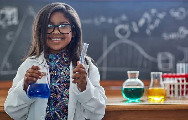 Je bent nooit te jong om een liefde voor de wetenschap na te streven. Portret van een klein meisje in een labjas die een wetenschappelijk experiment doet in een lab. — Stockfoto