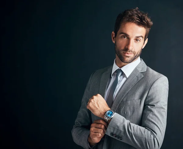 Dress like you mean business. Studio shot of a confident and stylishly dressed young businessman against a black background. — Stock Photo, Image