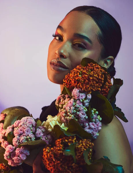 一个漂亮的安排。一个漂亮的年轻女子拿着一束鲜花在五彩斑斓的背景下摆姿势的工作室肖像. — 图库照片