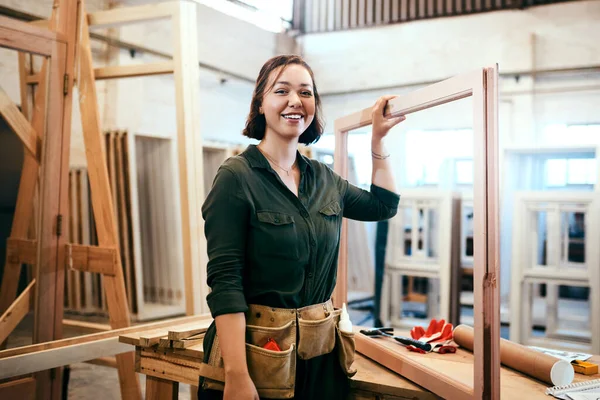 I just started a new project. Cropped shot of a female carpenter holding a wooden frame in her workshop. — Stock Photo, Image