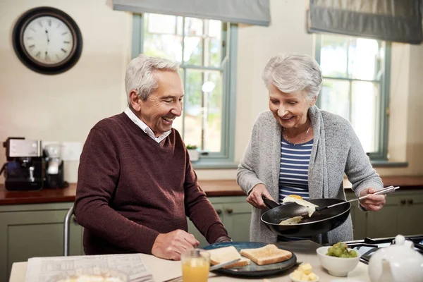 早餐准备好了拍到一对深情的老夫妇在自家厨房里一起做饭. — 图库照片