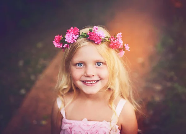¿Podemos quedarnos un poco más? Foto de una niña feliz mirando a la cámara y sonriendo mientras estaba de pie en medio de un camino de tierra. — Foto de Stock