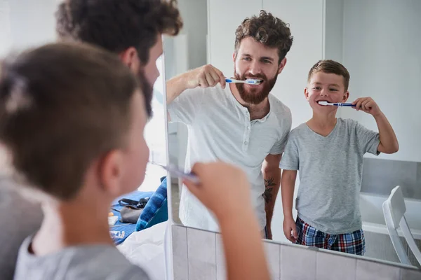 Začít dobré ústní návyky brzy. Zastřelili otce a jeho malého syna, jak si doma čistí zuby v koupelně.. — Stock fotografie