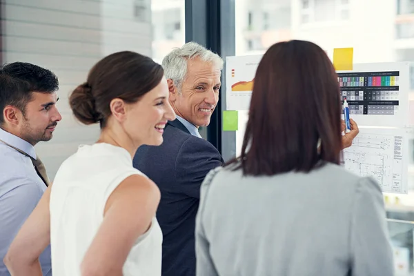 Ill show you what I have in mind. Cropped shot of a group of businesspeople looking at graphs together. — ストック写真