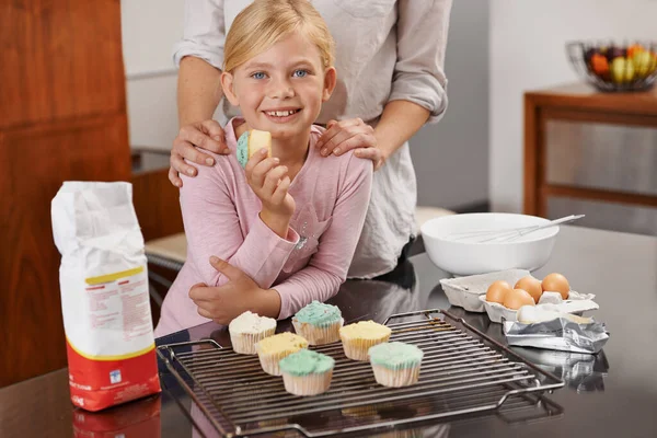 Lekkere triomf. Shot van een schattig klein meisje en haar moeder pronken met de resultaten van hun bakken. — Stockfoto