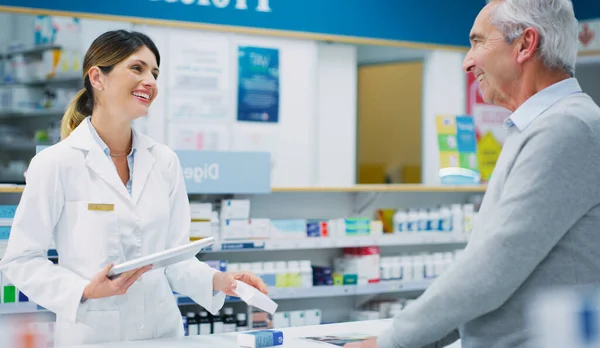 Se va con una receta llena y una gran sonrisa. Inyección de un farmacéutico asistiendo a un cliente en un químico. — Foto de Stock