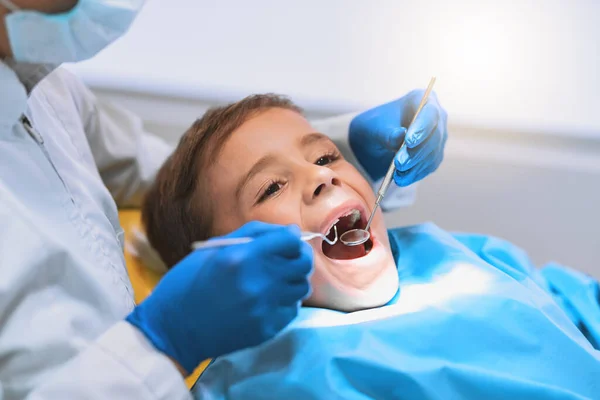 在这之后，我会有一个灿烂的微笑。拍了一个小男孩躺在牙医椅子上接受牙医检查的照片. — 图库照片