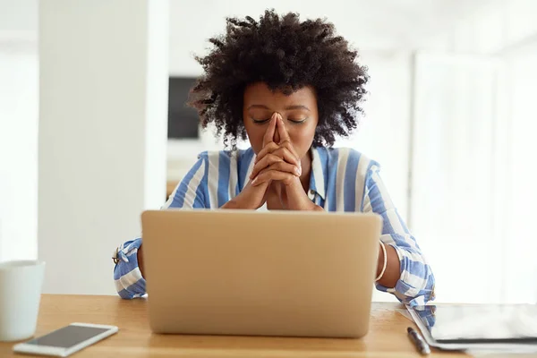 Questo potrebbe rivelarsi un grosso problema.... Colpo ritagliato di una giovane donna che guarda stressato mentre lavora sul suo computer portatile a casa. — Foto Stock