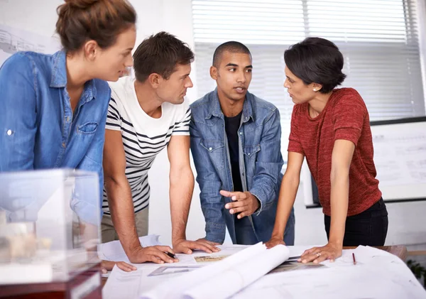 Explaining his design concept. Shot of a group of young designers working together in an office. — ストック写真