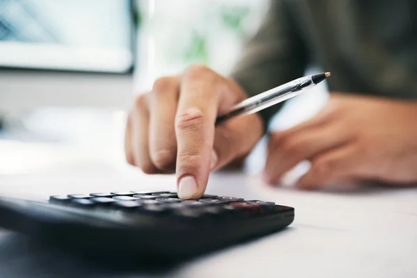 Deixe-me calcular isso. Tiro de um empresário irreconhecível usando uma calculadora em um escritório. — Fotografia de Stock