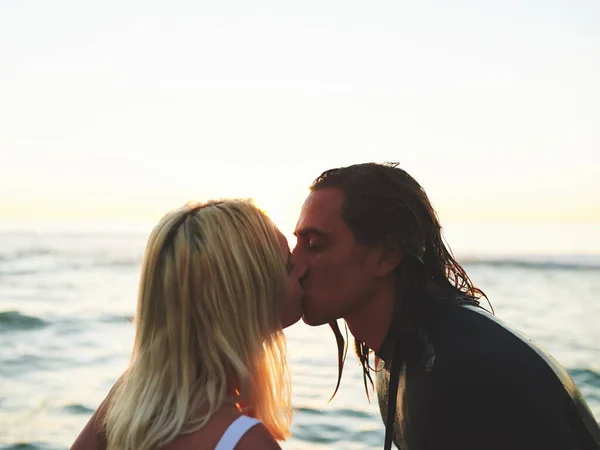 Il nostro amore è profondo come l'oceano. Colpo ritagliato di una giovane coppia affettuosa che si bacia sulla spiaggia al tramonto su uno sfondo dell'oceano. — Foto Stock