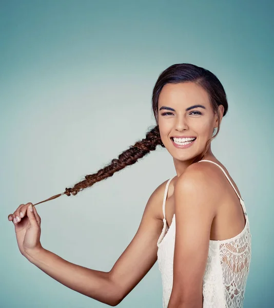 Njut av ditt hår speciellt när det är så här snyggt. Studio skott av en vacker ung kvinna poserar mot en grön bakgrund. — Stockfoto