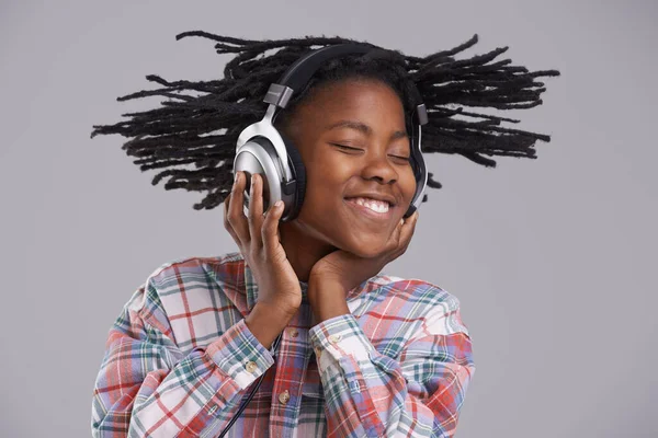 Peitschen im Takt. Ein afroamerikanischer Junge hört Musik über Kopfhörer. — Stockfoto