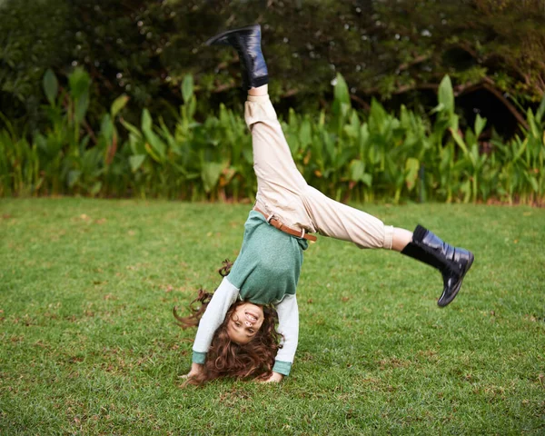 Hacer volteretas es muy divertido. Shot de una linda niña haciendo volteretas en la hierba. —  Fotos de Stock