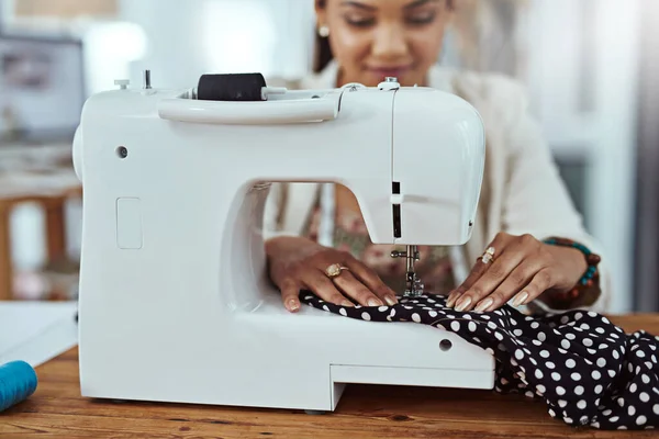 Ein paar Änderungen vornehmen. Schnappschuss einer jungen Modedesignerin mit einer Nähmaschine in ihrer Werkstatt. — Stockfoto