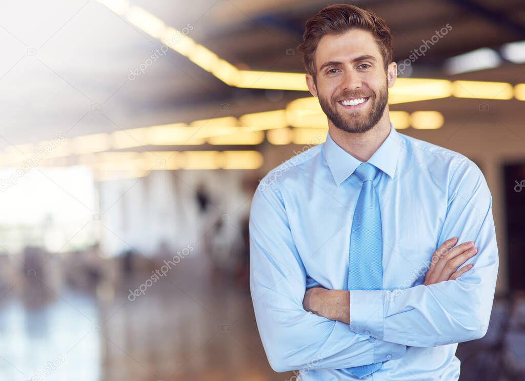 Success motivates me. Portrait of an ambitious young businessman standing with his arms folded in an office.