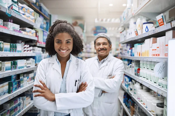 Готовий надати вам якісний сервіс. Обрізаний портрет двох фармацевтів, що стоять разом зі своїми руками, схрещеними в аптеці . — стокове фото