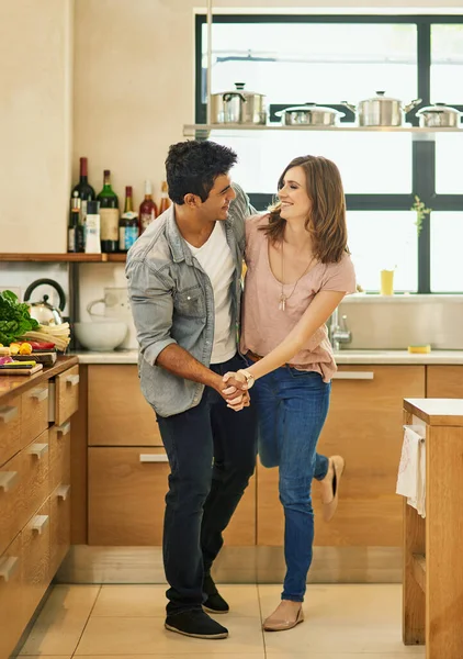 Dança e sê feliz. Tiro de um jovem casal carinhoso dançando na cozinha. — Fotografia de Stock