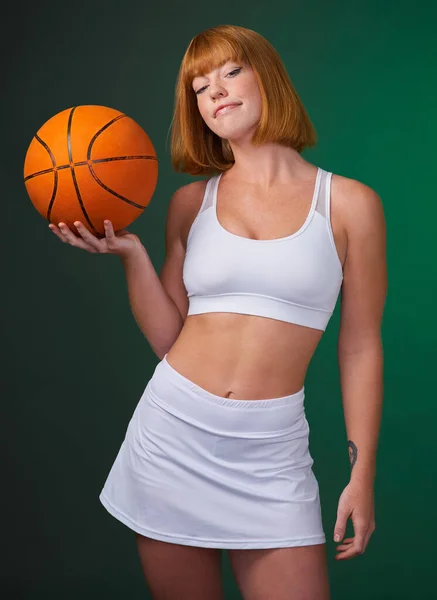 当人才不能努力工作时，努力工作胜过天赋。拍下了一个年轻迷人的女运动员独自站在演播室里，拿着一个绿色背景的篮球. — 图库照片