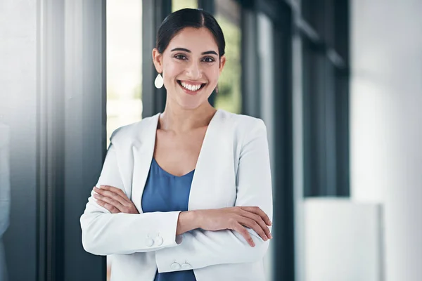 Она идеальное сочетание уверенности и позитивности. Портрет успешной предпринимательницы, стоящей со сложенными в офисе руками. — стоковое фото