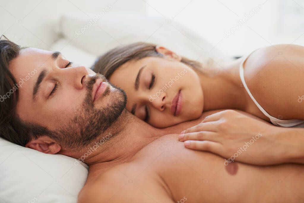 Who needs a teddybear when youve got each other. Shot of a young couple sleeping comfortably in bed.