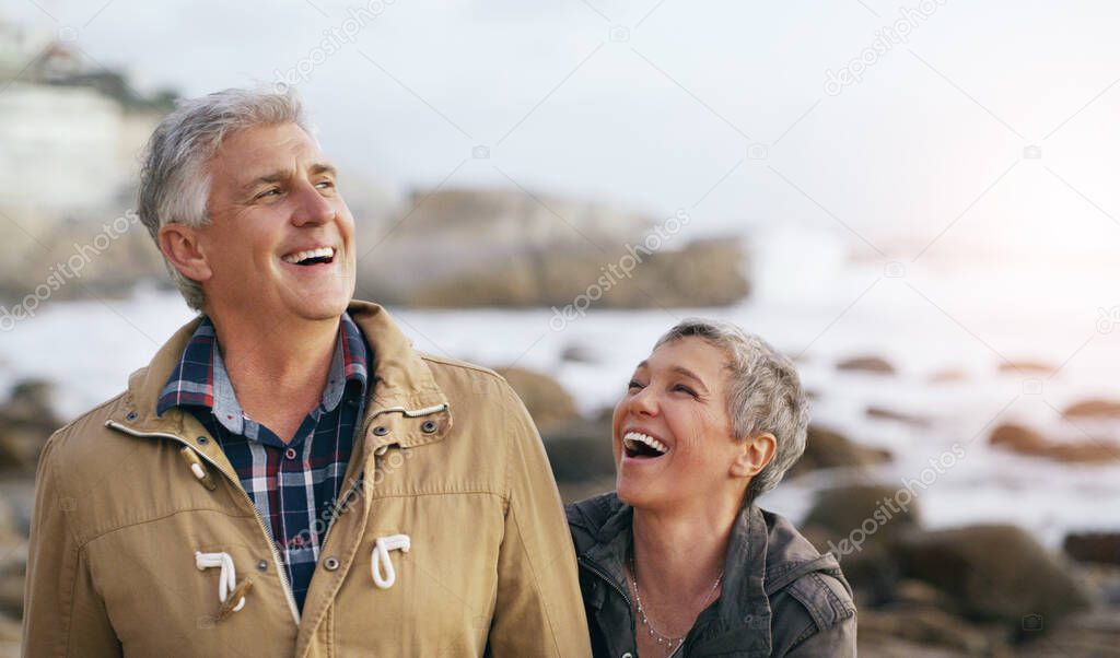 Weve always shared the best laughs together. Shot of a beautiful elderly couple taking a walk at the beach.