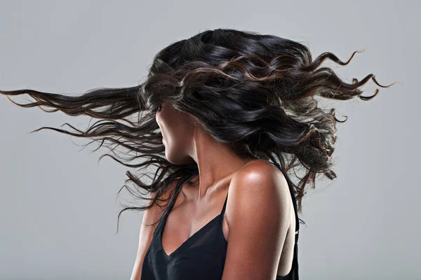 Este es un peinado. Estudio de una mujer joven con el pelo hermoso aislado en gris. — Foto de Stock