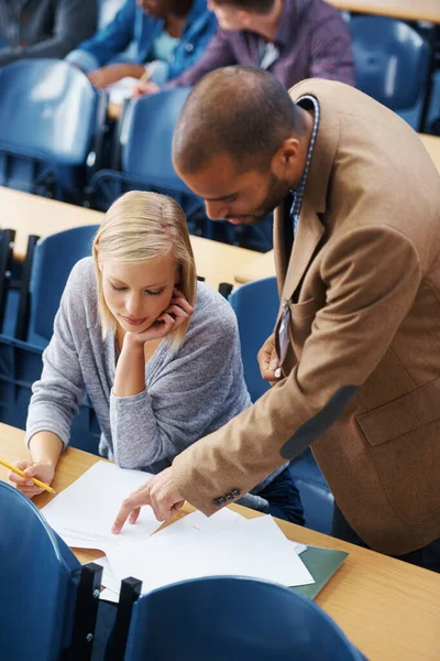 Clarifier la question. Prise de vue d'un professeur d'université pointant quelque chose sur un papier d'étudiants. — Photo