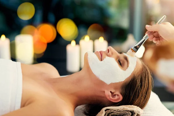 You can never have too many facials. Shot of a beautiful young woman lying on a massage table at the day spa. — ストック写真