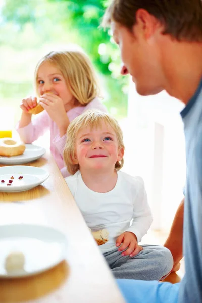 Uśmiechnięty chłopczyk z ojcem i siostrą jedzącymi śniadanie. Portret uśmiechniętego chłopca z ojcem i siostrą jedzącymi śniadanie. — Zdjęcie stockowe
