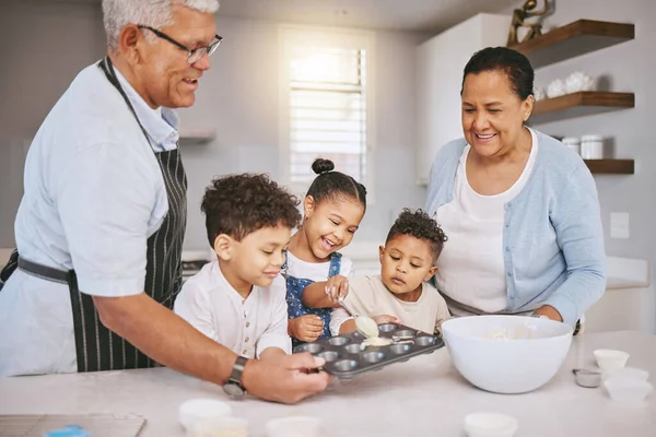 Bakjes halverwege vullen, op de juiste manier. Shot van een volwassen paar bakken met hun kleinkinderen thuis. — Stockfoto