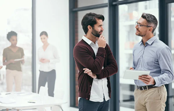 Laten we dit oplossen. Foto van twee collega 's die samenwerken op een digitale tablet in een kantoor. — Stockfoto