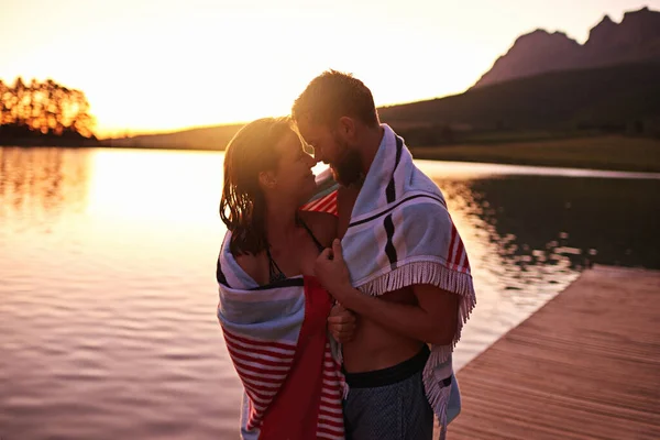 Nur wir beide.... Aufnahme eines liebevollen jungen Paares in Badeanzügen, eingewickelt in ein Handtuch an einem See. — Stockfoto