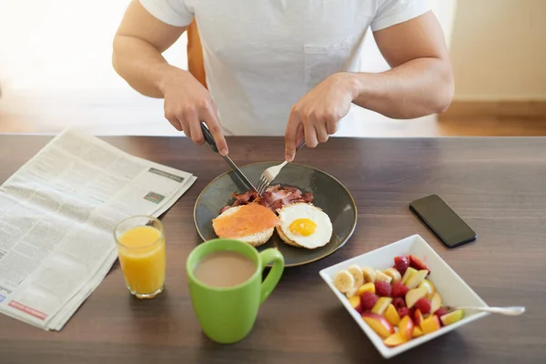 Aloita aamu kunnolla. rajattu laukaus poikamies nauttia aamiaista kotona. — kuvapankkivalokuva
