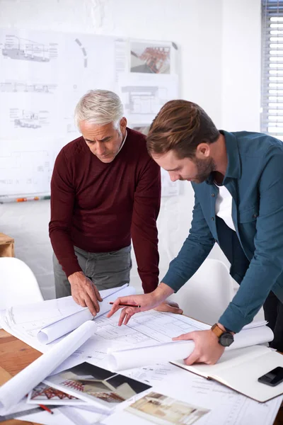 A dar os últimos retoques nos planos. Foto recortada de dois arquitetos trabalhando juntos em seu escritório. — Fotografia de Stock