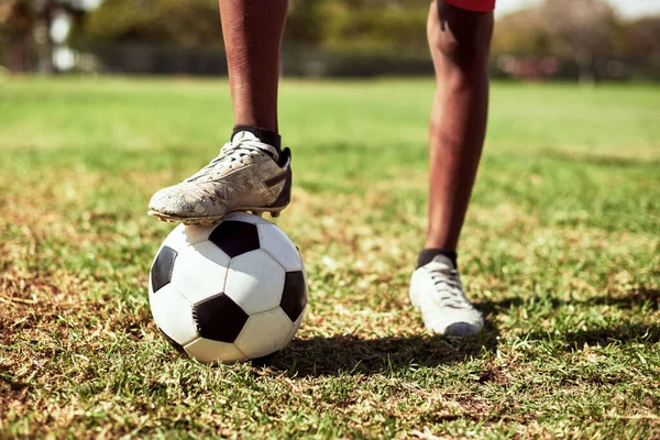 Você tem que ser rápido em seus pés neste jogo. Tiro de close-up de um menino jogando futebol em um campo de esportes. — Fotografia de Stock