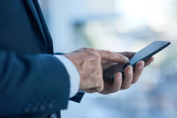 Succes draait om het leggen van de juiste verbanden. Close-up shot van een zakenman sms 'en op een mobiele telefoon in een kantoor. — Stockfoto
