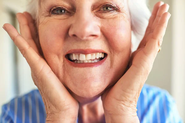 Krásně stárne, protože se pořád usmívá. Vystřižený záběr starší ženy doma. — Stock fotografie
