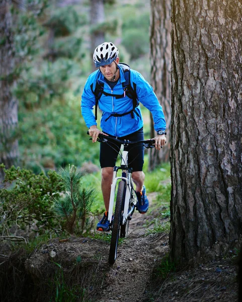 Ele é um determinado ciclista de montanha. Tiro de um ciclista masculino andando ao longo de uma trilha de bicicleta de montanha. — Fotografia de Stock