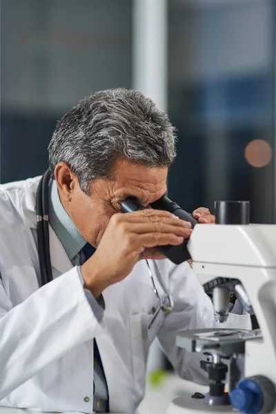 De lens liegt niet. Shot van een volwassen wetenschapper met behulp van een microscoop in een laboratorium. — Stockfoto