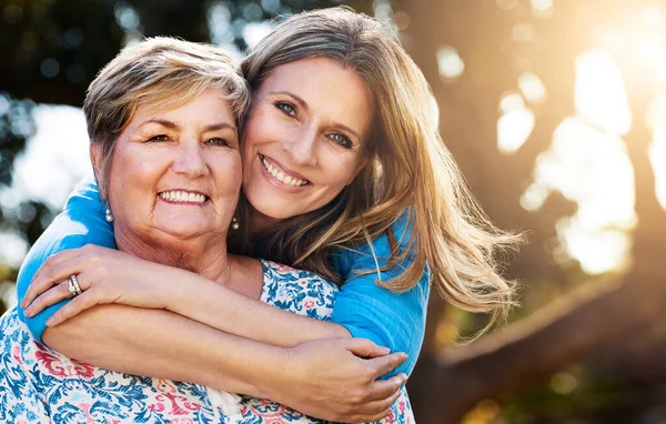 A minha mãe deu-me uma vida cheia de amor. Retrato de uma mulher madura feliz abraçando sua mãe ao ar livre. — Fotografia de Stock